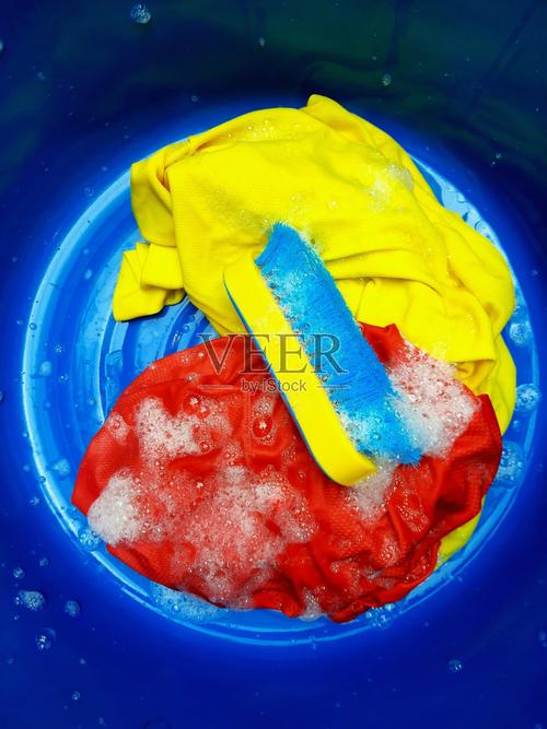 洗紅色和黃色的布洗滌劑泡沫藍色背景照片攝影圖片